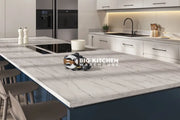 Modern kitchen featuring a spacious Vis Uma Square Edge Laminate Worktop island, four beige chairs, induction cooktop, bowl of grapes, salt and pepper shakers, white cabinets, sink, and stainless steel fridge.